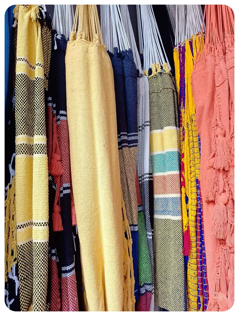 Hamacas tejidas en amarillo, azul marino, coral y rayas, colgadas